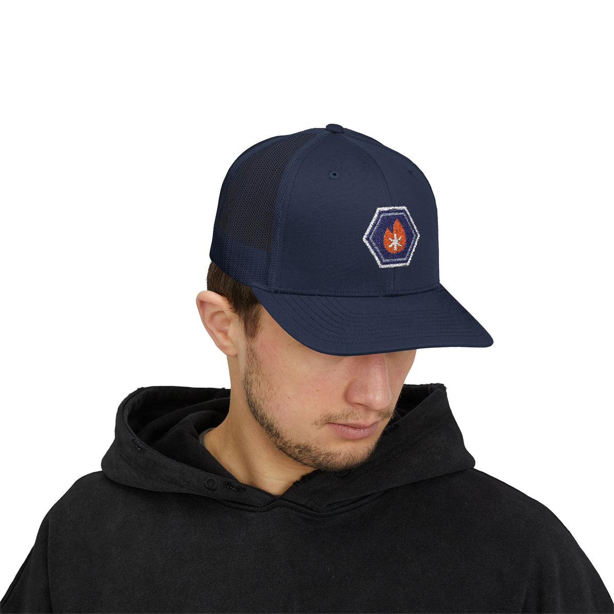 Person wearing a navy trucker hat with an embroidered fire-and-ice hex nut logo