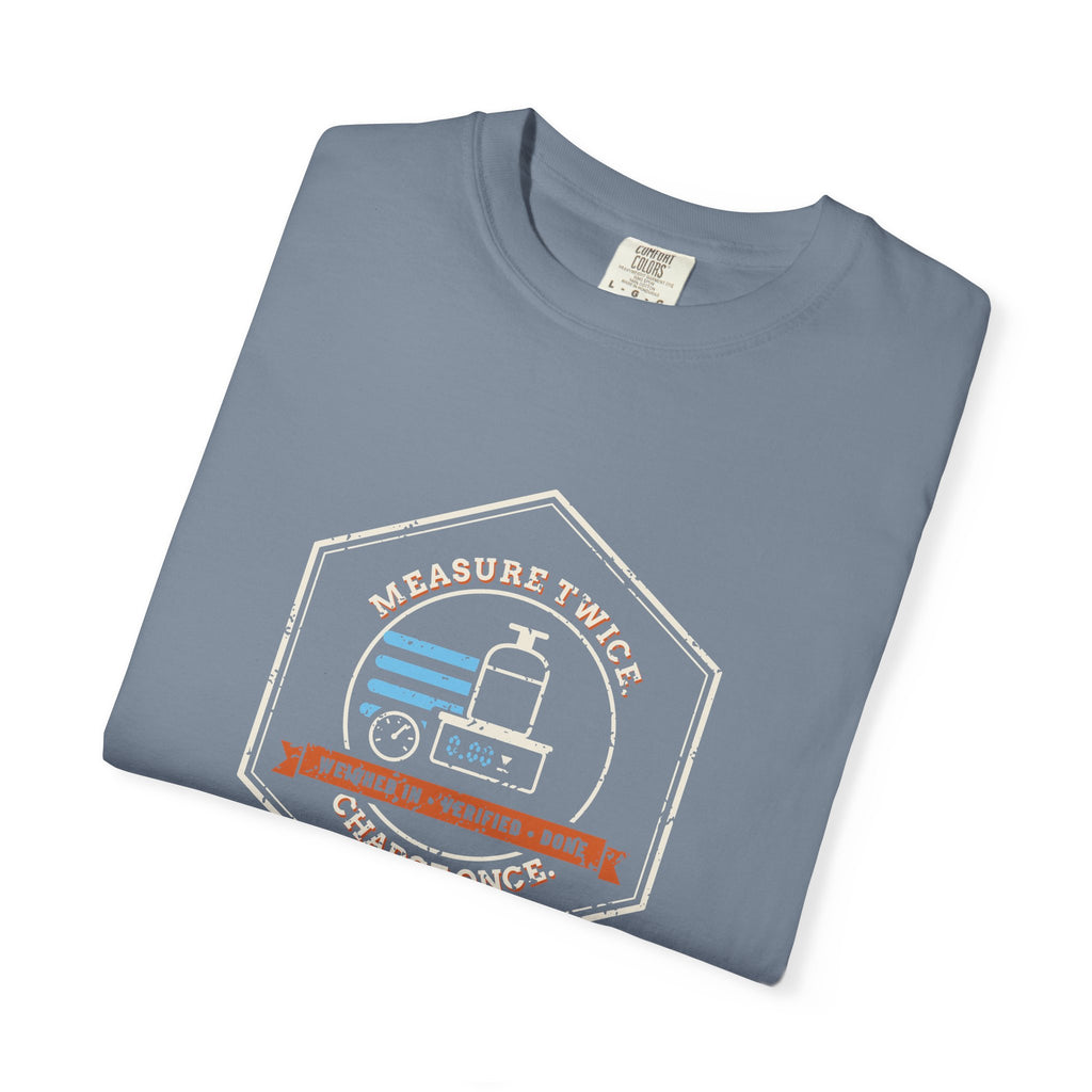 Folded Blue Jean t-shirt with a retro Measure Twice. Charge Once. hex badge with a cylinder on a scale
