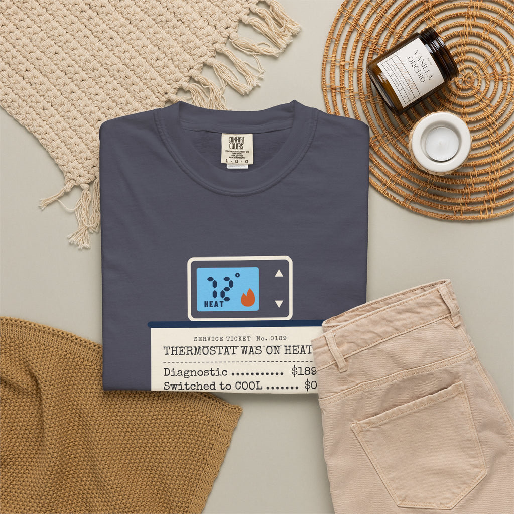 Folded navy t-shirt reading Thermostat Was on Heat. Diagnosis: $189. with a simple thermostat graphic