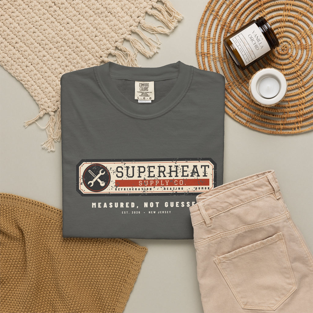 Folded faded black t-shirt with a vintage equipment data plate reading Superheat Supply Co., Refrigeration Heating Humor