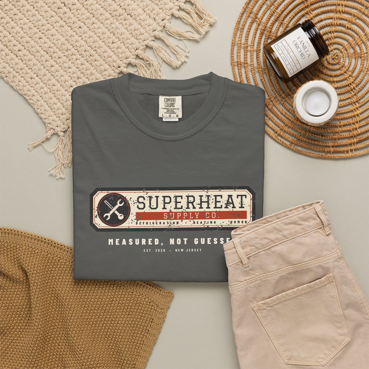 Folded faded black t-shirt with a vintage equipment data plate reading Superheat Supply Co., Refrigeration Heating Humor