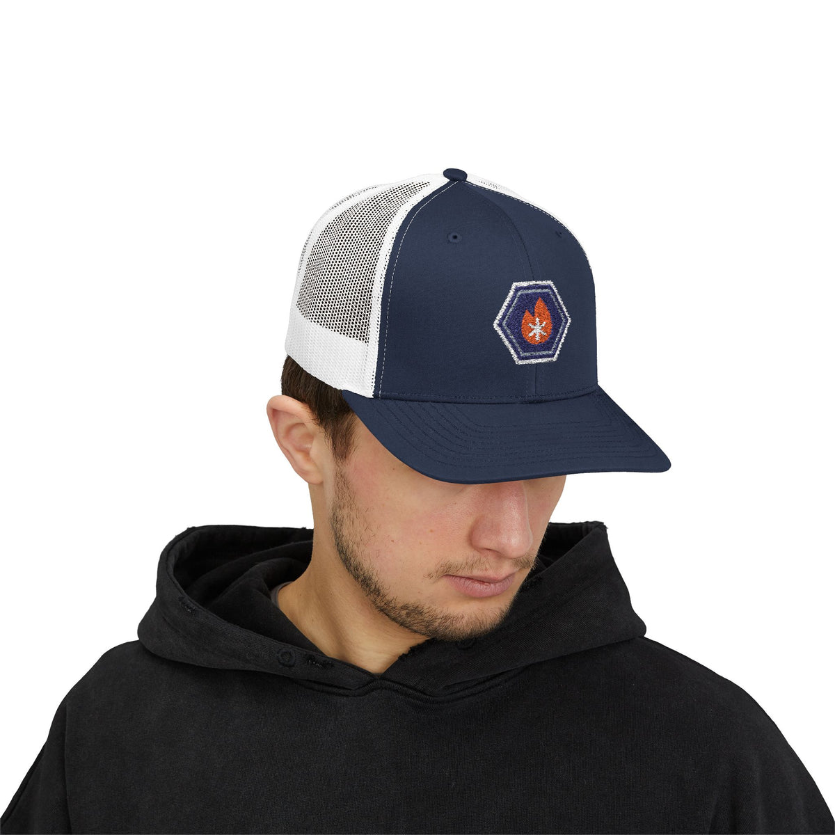 Person wearing a navy and white trucker hat with an embroidered fire-and-ice hex nut logo