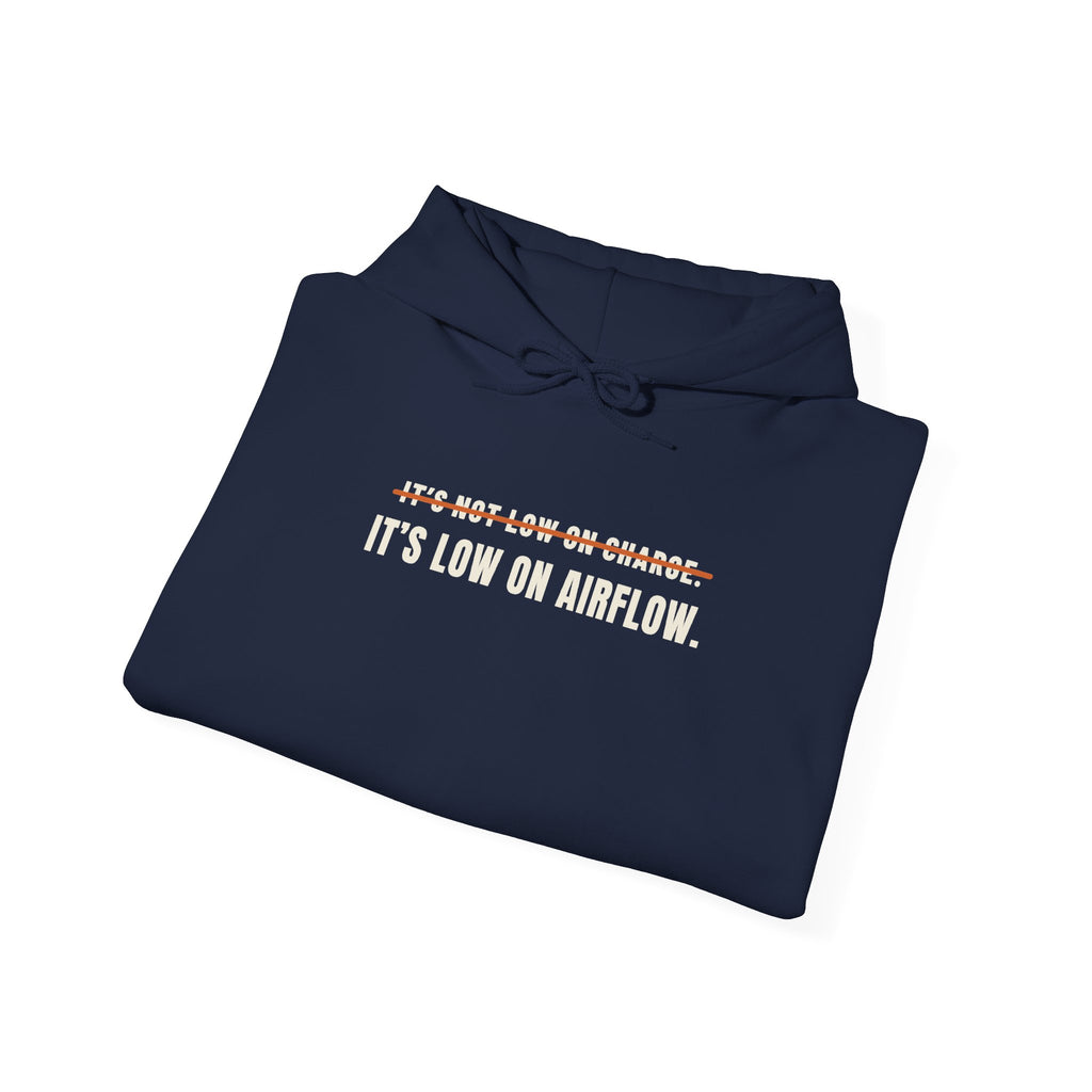 Folded navy hoodie reading It's Not Low on Charge, struck through, then It's Low on Airflow across the chest
