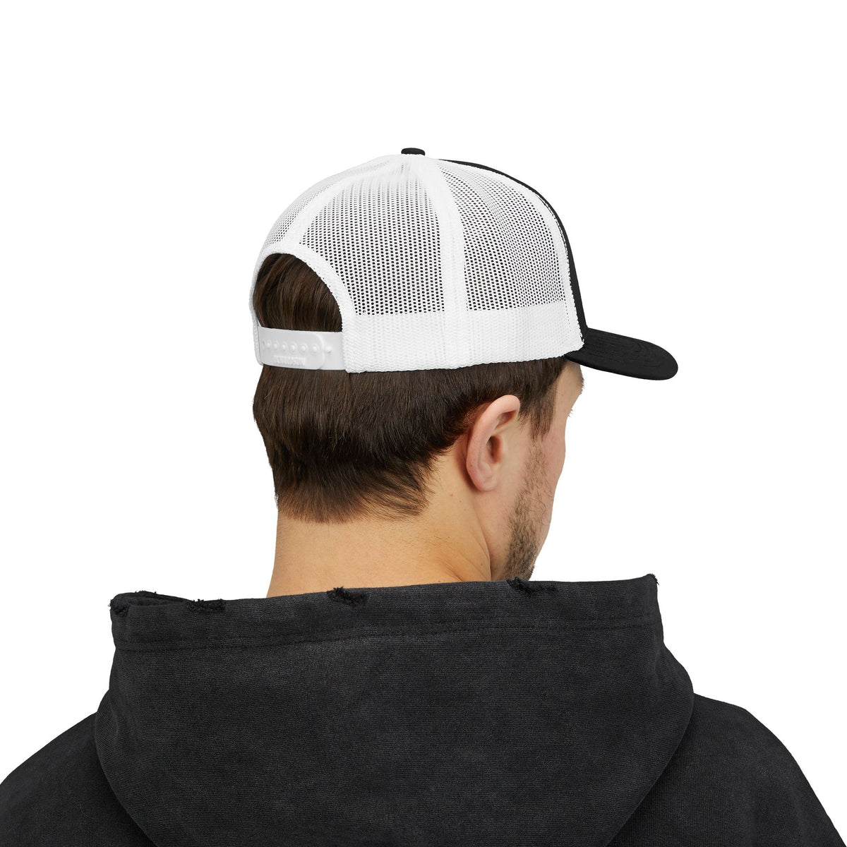 Person wearing the black and white trucker hat, seen from the back with white mesh panels and a snapback