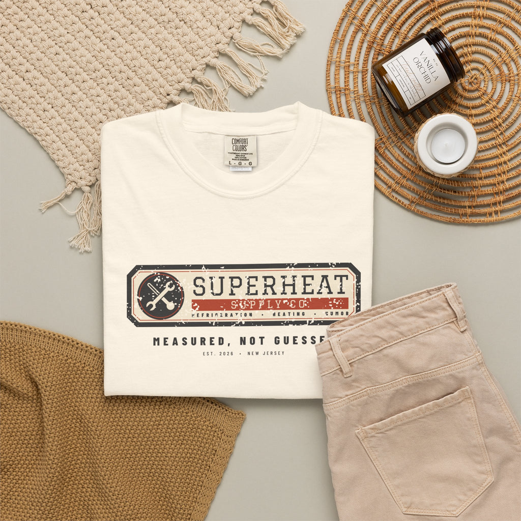 Folded ivory t-shirt with a vintage equipment data plate reading Superheat Supply Co., Refrigeration Heating Humor