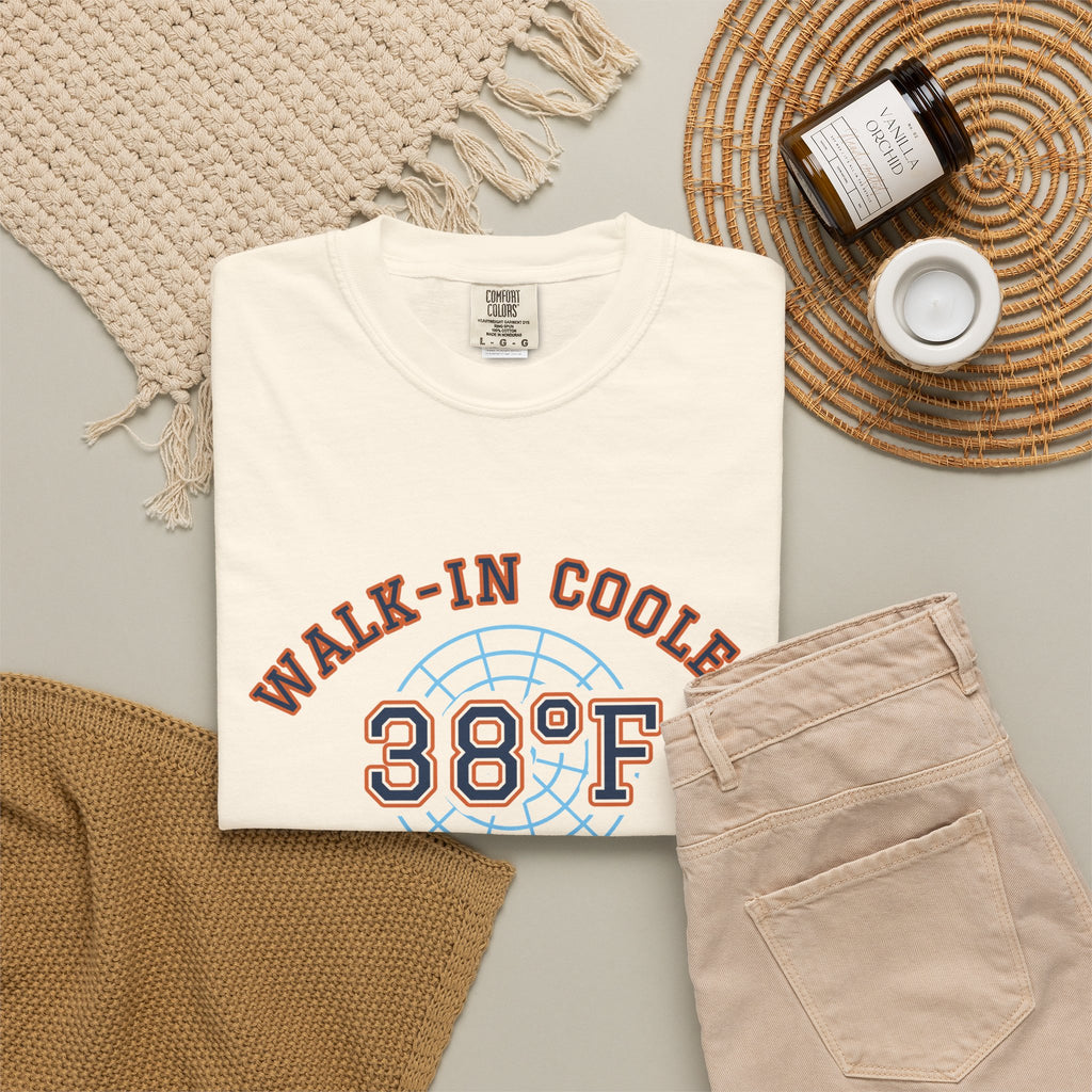 Folded ivory t-shirt with a walk-in cooler door badge reading Walk-In Cooler Crew, Box Temp 38°F