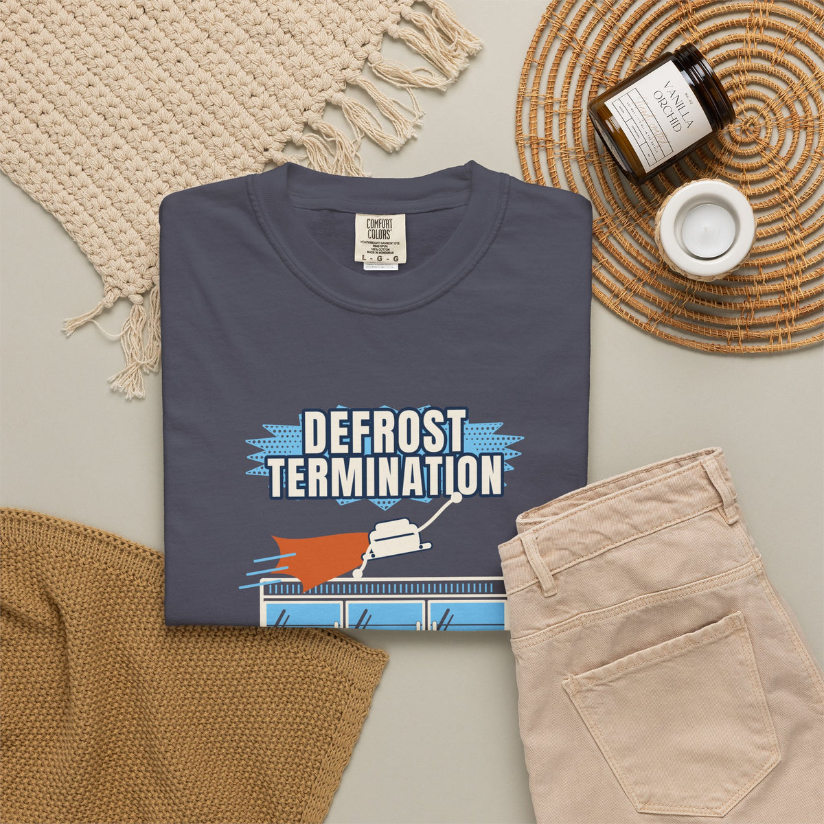 Folded navy t-shirt reading Defrost Termination, The Real Hero of the Frozen Aisle, with a frosted coil graphic
