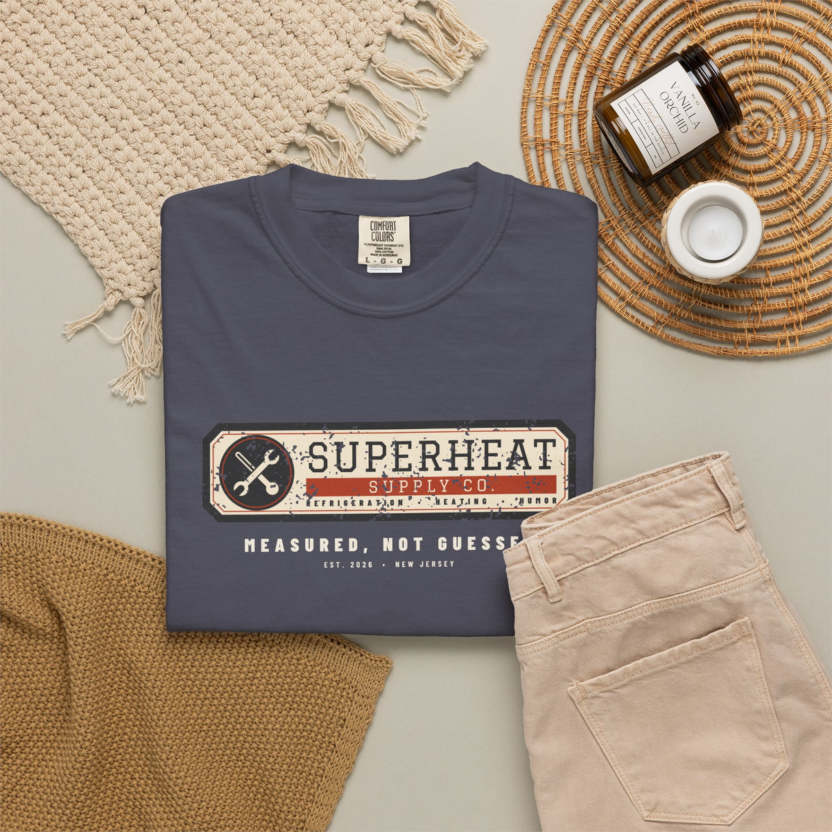Folded navy t-shirt with a vintage equipment data plate reading Superheat Supply Co., Refrigeration Heating Humor