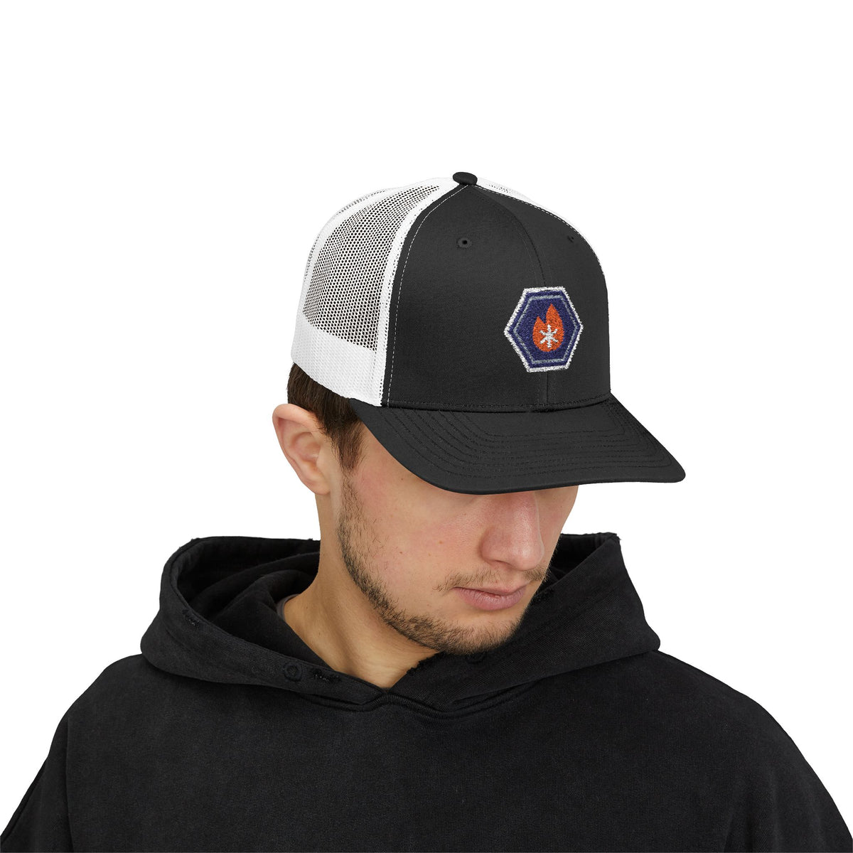 Person wearing a black and white trucker hat with an embroidered fire-and-ice hex nut logo
