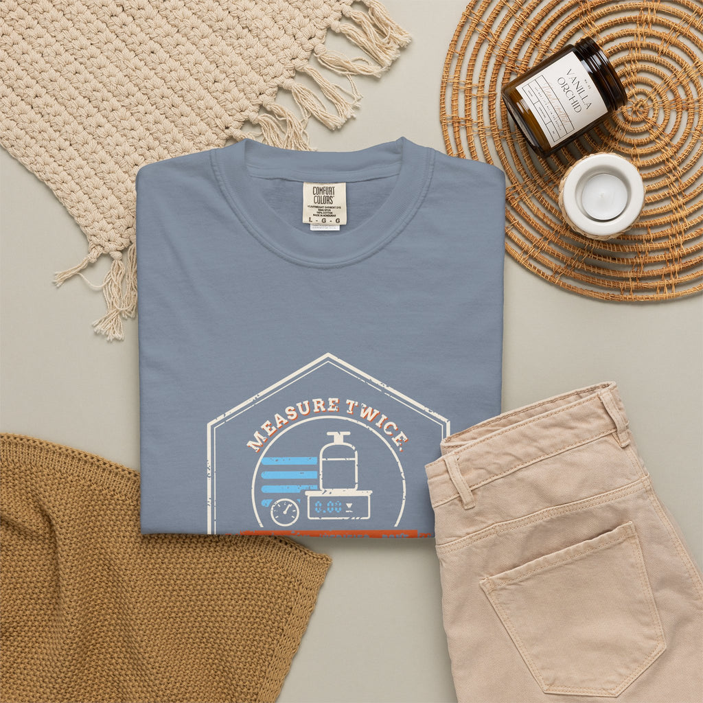 Blue Jean t-shirt flat-lay with a retro Measure Twice. Charge Once. hex badge with a cylinder on a scale